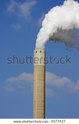 Factory pipe with white smoke against a blue sky