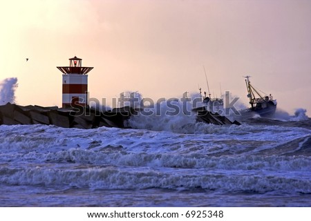 Storm at the north sea with fisherboat going out of the harbor at Scheveningen in Holland at sunset
