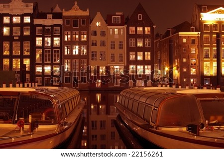 Amsterdam houses and cruise boats by night