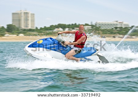 Young guy cruising on the atlantic ocean on a jet ski