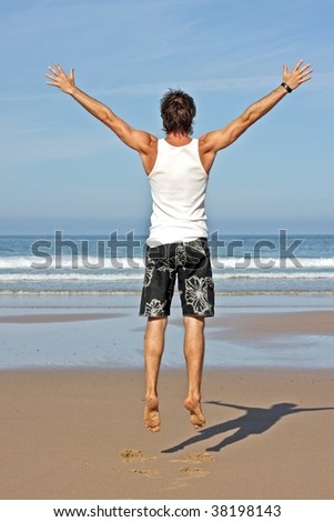 Young man jumping in the air out of joy at the atlantic ocean