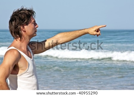 stock photo Young guy pointing far away over the ocean