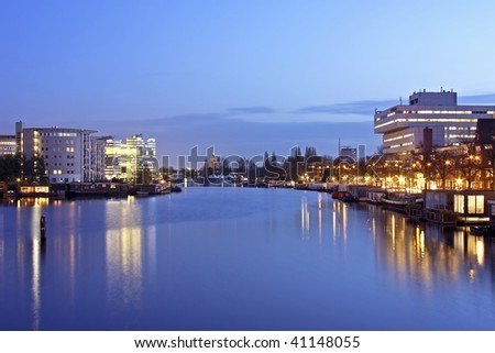 Amsterdam city by night in the Netherlands with the river Amstel