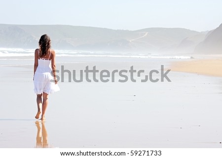 Lonely young woman walking on the beach