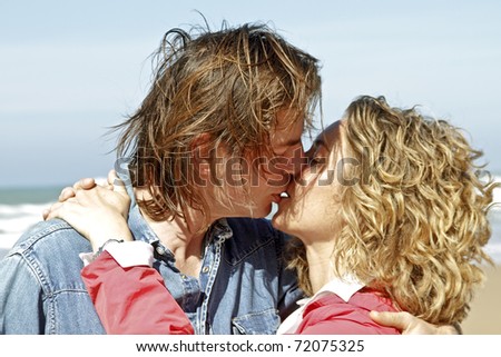 Young couple in love kissing eachother at the beach