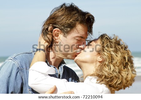 Young couple in love kissing each other at the beach