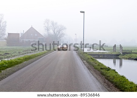 Car driving in the fog in the countryside from the Netherlands