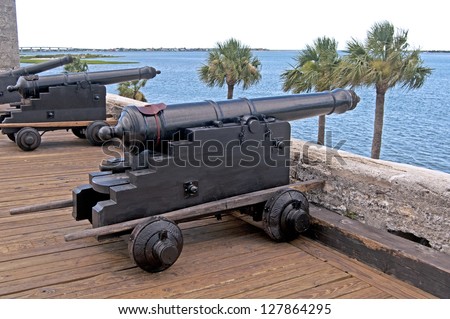 Old canons aiming at the sea, in a fort, on an overcast day. Castillo de San Marcos, St. Augustine, Florida. 16th century.