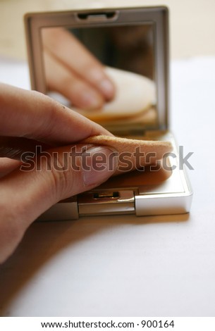 close up of woman\'s hand applying face powder, more in my gallery
