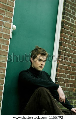 Good Looking Young Guy sitting in front of brick wall