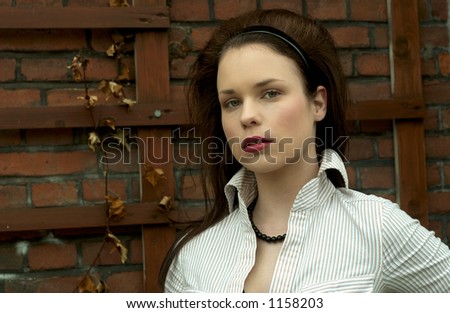 Beautiful girl standing in front of a brick wall background, romantic/gothic look
