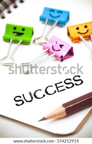 success word on paper with pencil and clips