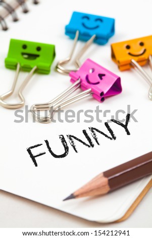 funny word on paper with pencil and clips