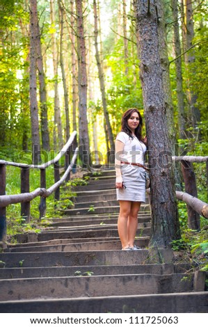 An image o girl walking through the forest pathway