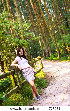An image o girl walking through the forest pathway
