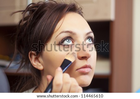An image of girl making up