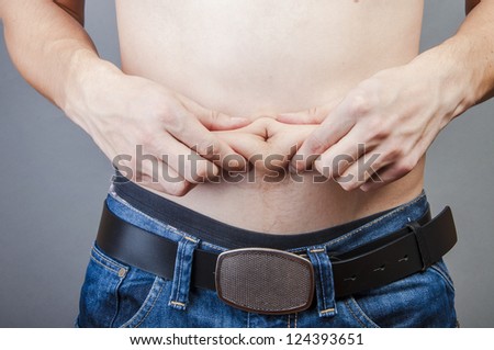 An image of man hold his fat on stomach