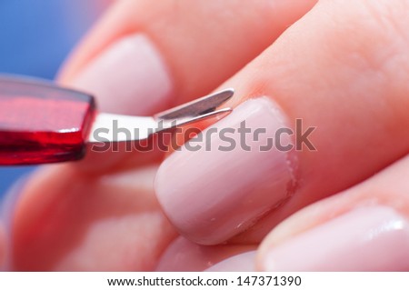 an image of girl cuts the skin at the nail