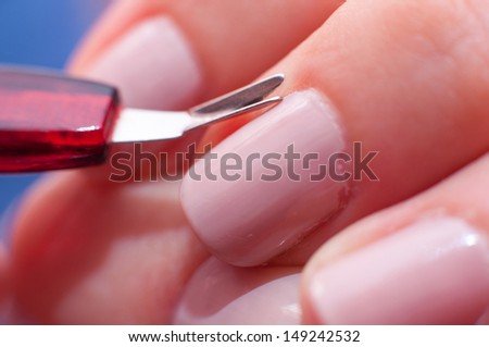 an image of girl cuts the skin at the nail