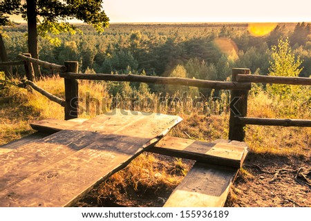 an image of wooden picnic tables in the woods