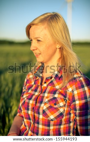 portrait of freckled blonde outside wearing a plaid shirt