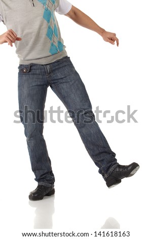 Tap dancer in blue jeans and tap shoes doing steps on a white background and floor