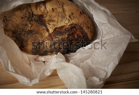 Fresh homemade traditional Moroccan bread loaves wrapped in paper on a cutting board