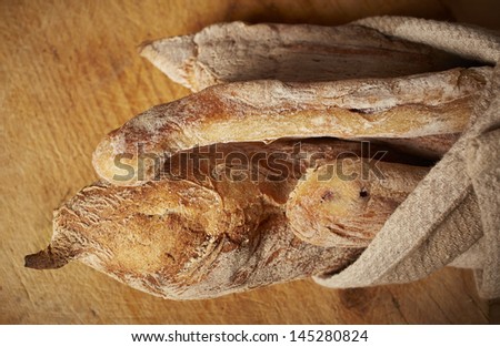Fresh homemade traditional Moroccan bread loaves wrapped in a rough cotton cloth on a cutting board