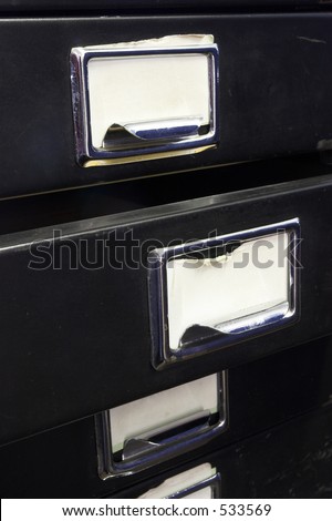 Close-up of a black mini filing cabinet and label with one open drawer