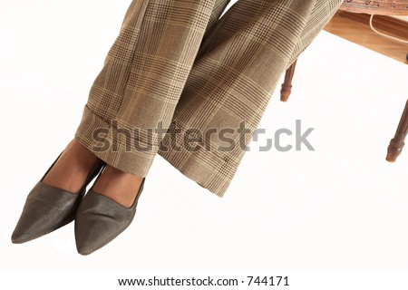 Feet of an African business woman dressed in neutral coloured clothes.  Sitting on a chair.