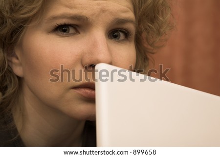 Worried Woman behind Notebook Computer