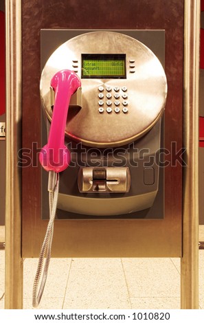 A diryt public payphone in a trainstation.