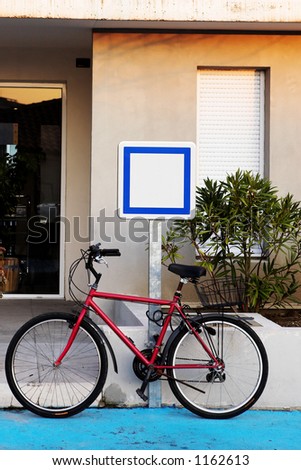 A bicycle in front of a sign, copy space.