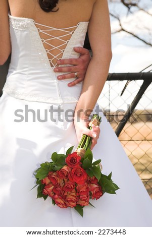 stock photo : Young Bride with white wedding gown - Luxurious red roses behind her back