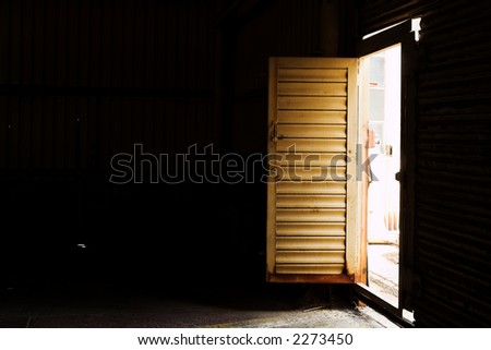 Open door to an industrial warehouse - shaft of light, High contrast