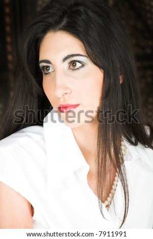 Beautiful young adult Italian businesswoman with long black hair, pearls and a white blouse