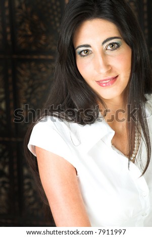 Beautiful young adult Italian businesswoman with long black hair, pearls and a white blouse