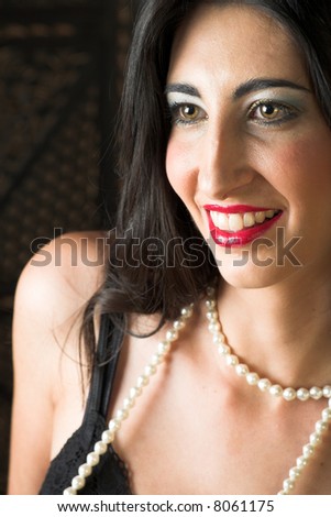 Beautiful young sexy adult Italian woman with long black hair, and a string of pearls, in black lace lingerie on a textured wooden background – Hard light, high key