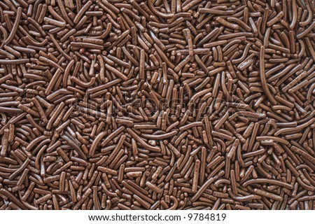 A bed of brown chocolate sprinkles used for cake decoration and dessert toppings. Can be used as a texture or background