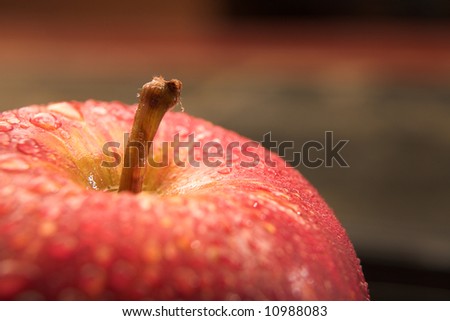 Fresh red apple with drops of water on a black glass backdrop - Shallow Depth of Field