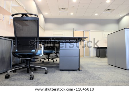 Empty office with new modern office furniture, including desks, cupboards, filing cabinets and chairs. Two orange chairs facing out. HDR type image