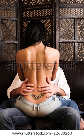 stock photo Multiethnic couple in passionate embrace and undressing each 
