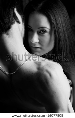 Young adult Caucasian couple in passionate embrace and undressing each other during sexual foreplay