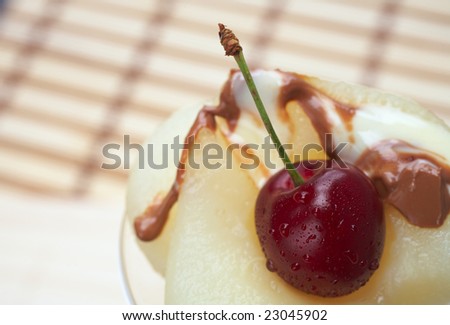 Fresh pear and cherry desert with melted white and milk chocolate topping