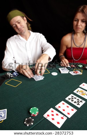People playing cards, chips and players gambling around a green felt poker table. Shallow Depth of field
