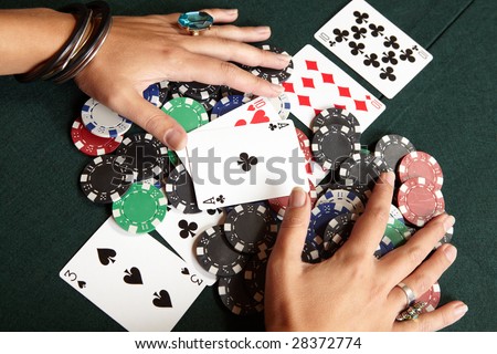 Winning hand, three of a kind, Aces high. Playing cards, chips and player pulling winnings to herself on a green felt poker table