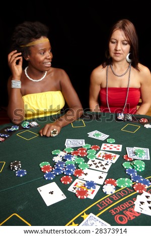 Woman playing cards, chips and players gambling around a green felt poker table. Shallow Depth of field