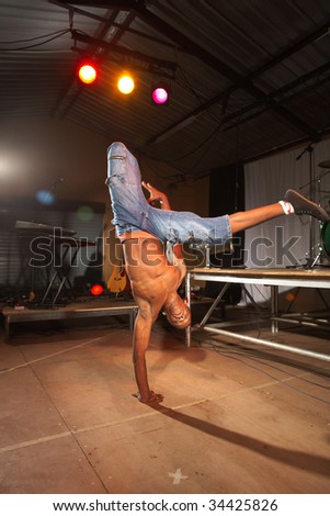 Single African freestyle hip-hop dancer at a training session on stage with instruments in the background