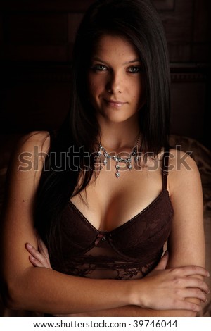Sexy young adult caucasian woman in black lingerie with high contrast lighting