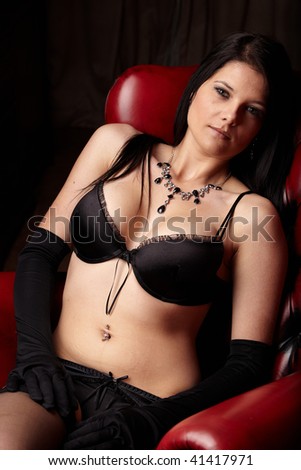 Sexy young adult caucasian woman in black lingerie with high contrast lighting